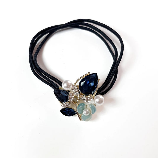 Navy blue botanical crystal hair tie with marquise leaf charm and pearl beads on black elastic band
