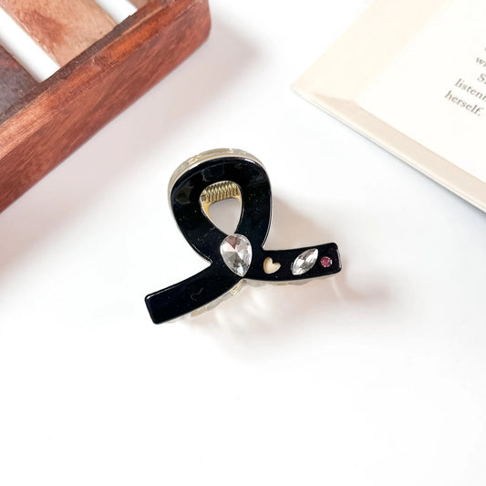 Black bow claw clip with crystal and heart cutout detail