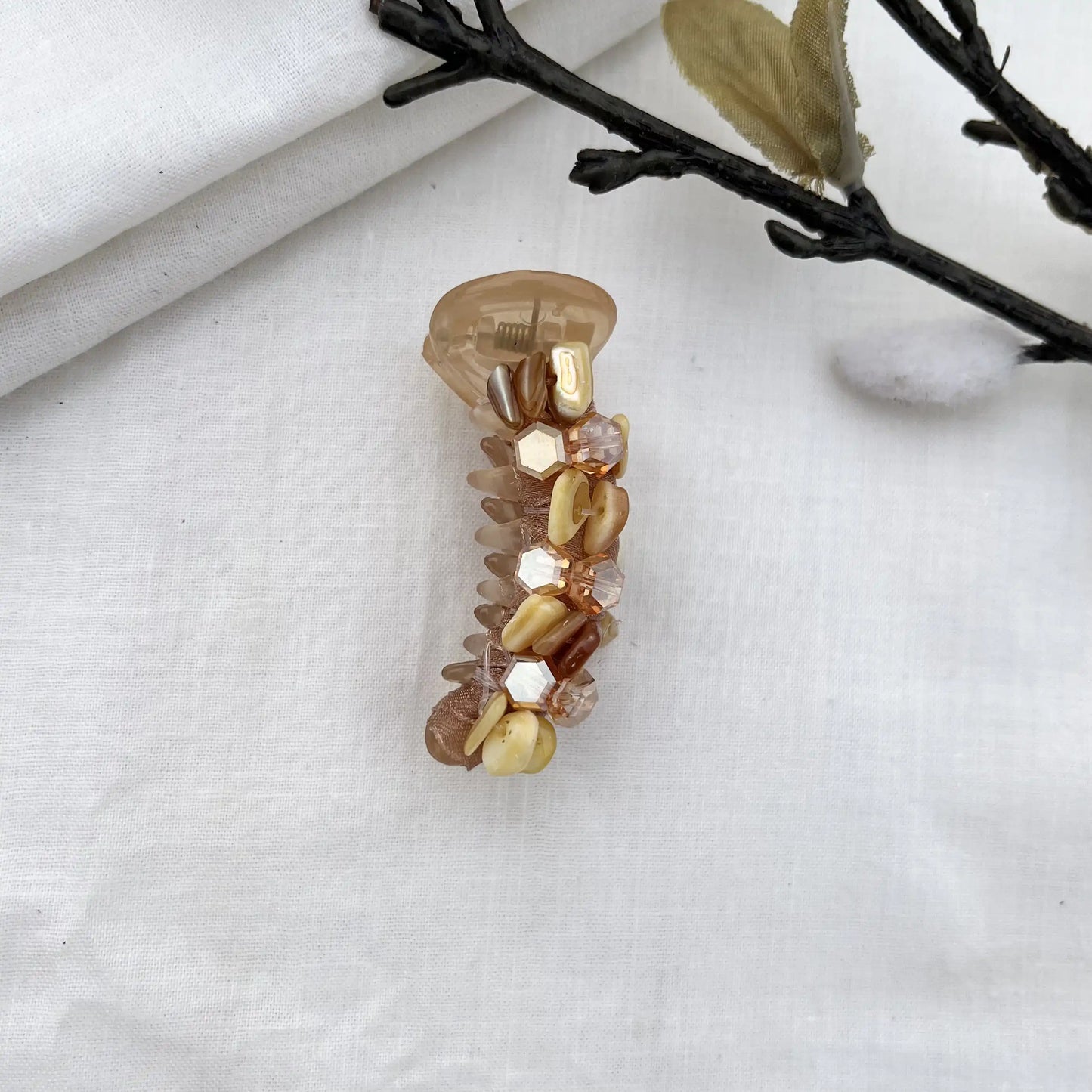 Warm caramel-toned dainty mini banana clip with golden faceted beads and polished finish.