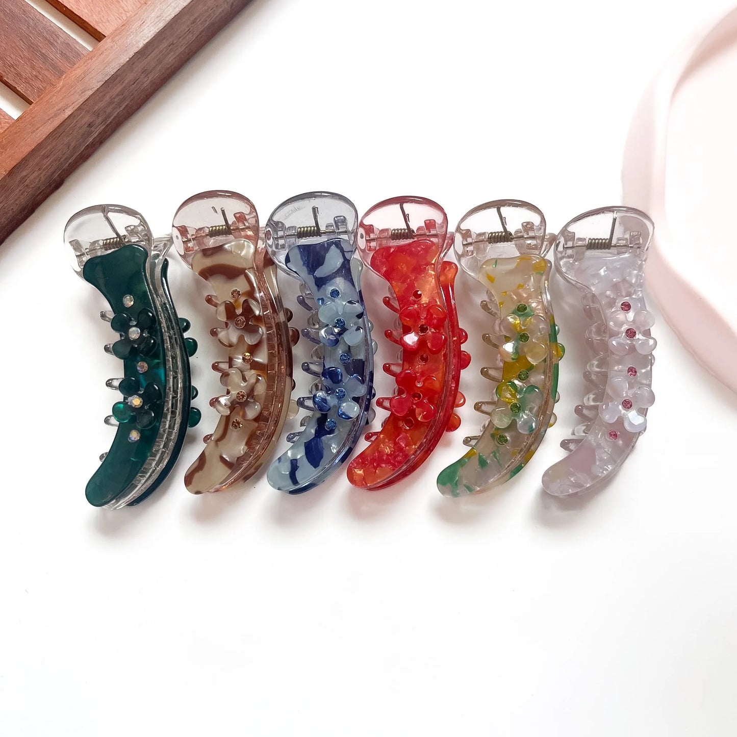 Marble floral banana clips in teal, brown marble, blue marble, red, multicolour and grey with 3D flower clusters