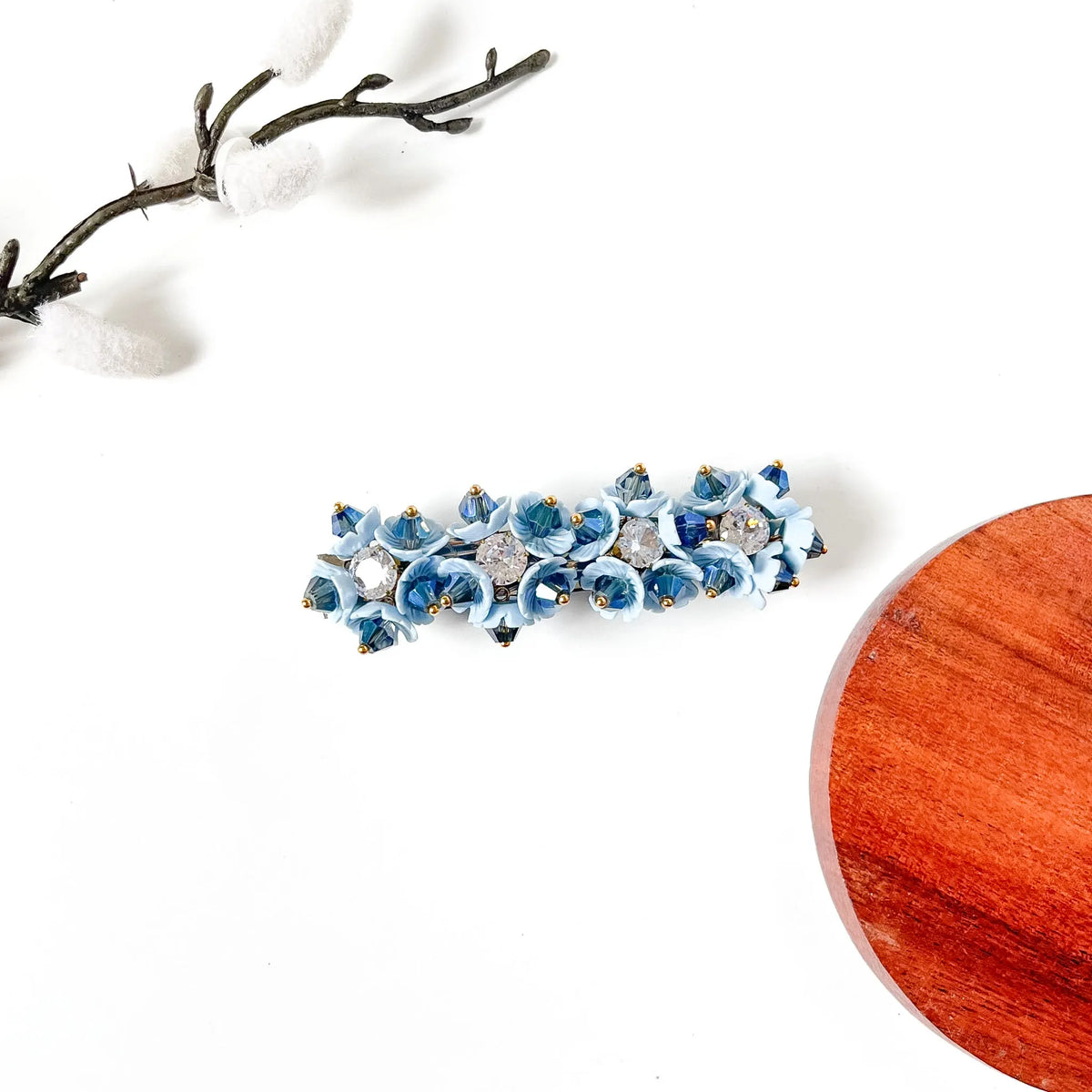 Sky blue porcelain bell flower hair clip with navy blue crystals and CZ stones on a gold barrette