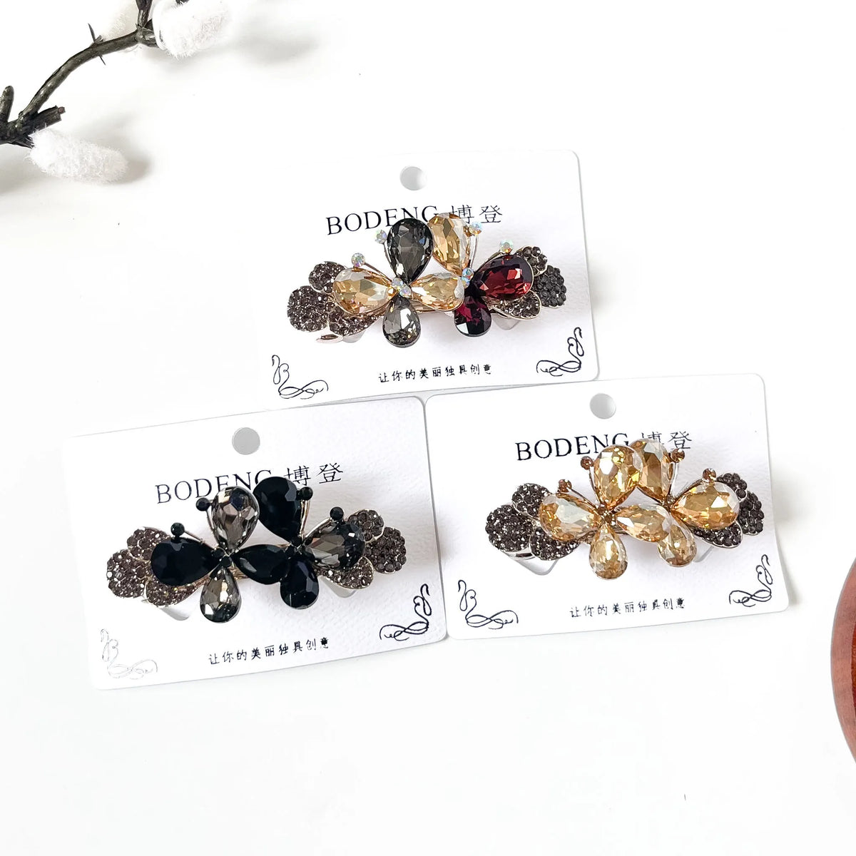 Twin Flutter crystal butterfly barrettes in champagne gold, noir black and harvest multicolour