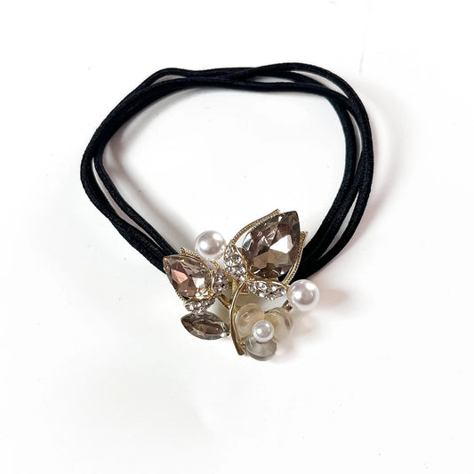 Silver botanical crystal hair tie with marquise leaf charm and pearl beads on black elastic band