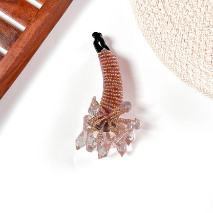 Caramel metallic crystalline banana clip with faceted rose-gold crystals and blush-pink gemstone cluster.