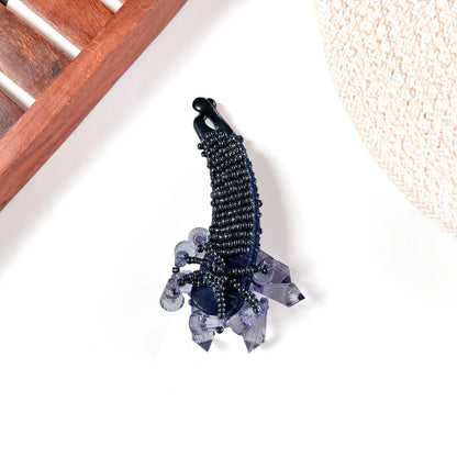 Navy iridescent crystalline banana clip with multicolour faceted crystal body and jewel-tone base stones.