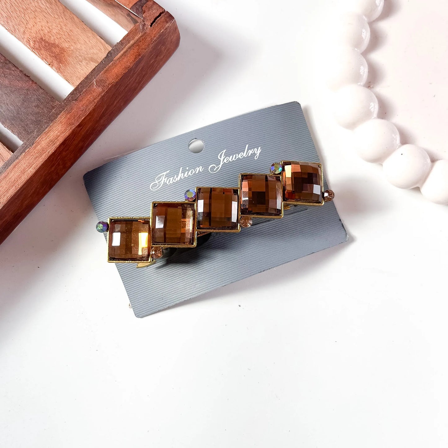 Warm amber-brown cube gemstone center clip featuring faceted square stone and gold-tone alloy metal frame, packaged.