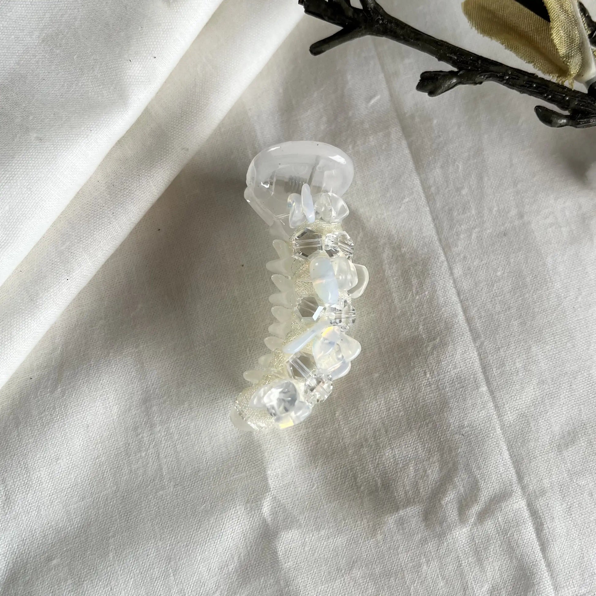 5cm clear crystal dainty mini banana clip with delicate faceted beads in minimalist design against cream background.