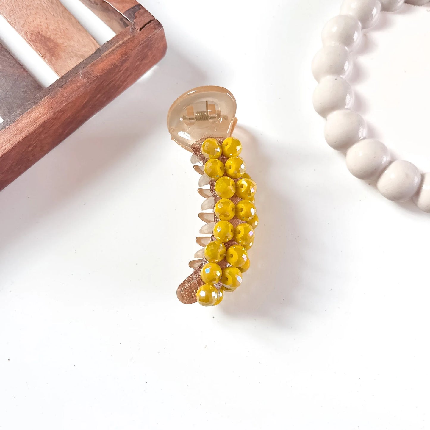 Warm caramel acrylic dome bead banana clip with golden-yellow faceted dome bead embellishments and shiny casing.