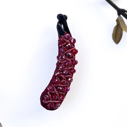 Handcrafted red crystal banana clips with intricate beadwork on fabric base