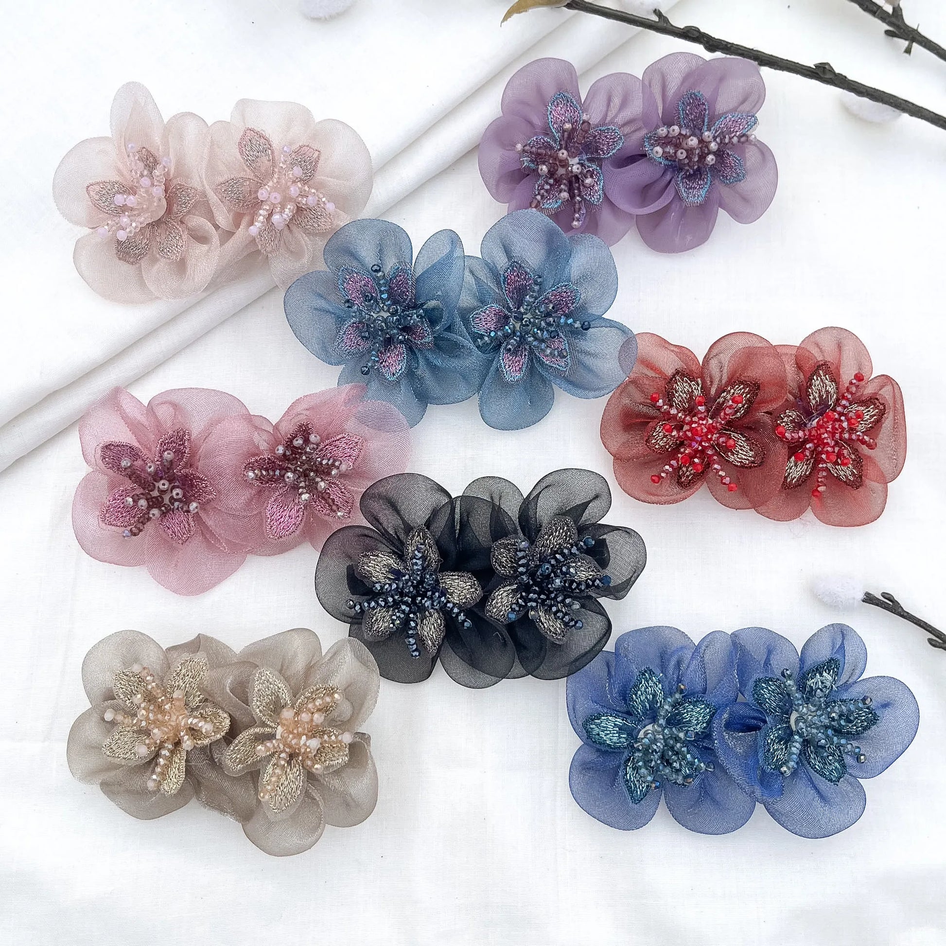 Color swatch: all 8 embroidered blossom clip shades on white surface