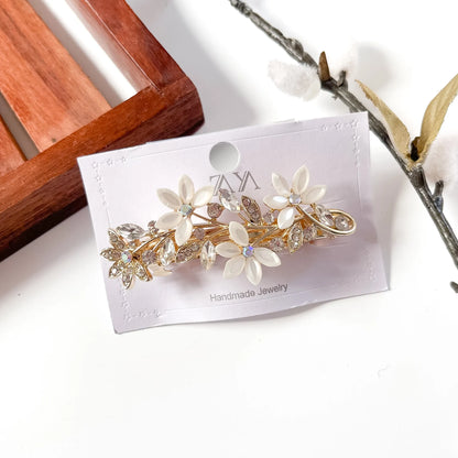 Floral gold barrette with white petal flowers and rhinestones on packaging card