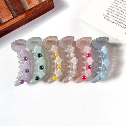 Set of decorative banana clips with colorful beads on a white surface.