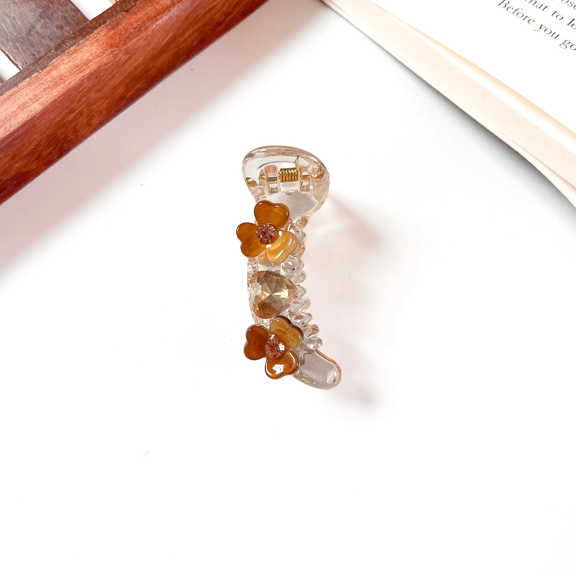 Brown mini banana clip with flower details and faceted rhinestone accents, 6cm
