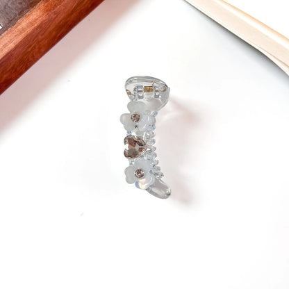 Blue mini banana clip with floral gems and sparkling rhinestone details, 6cm