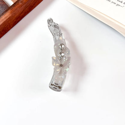 White iridescent lock banana clip with flower and crystal detail
