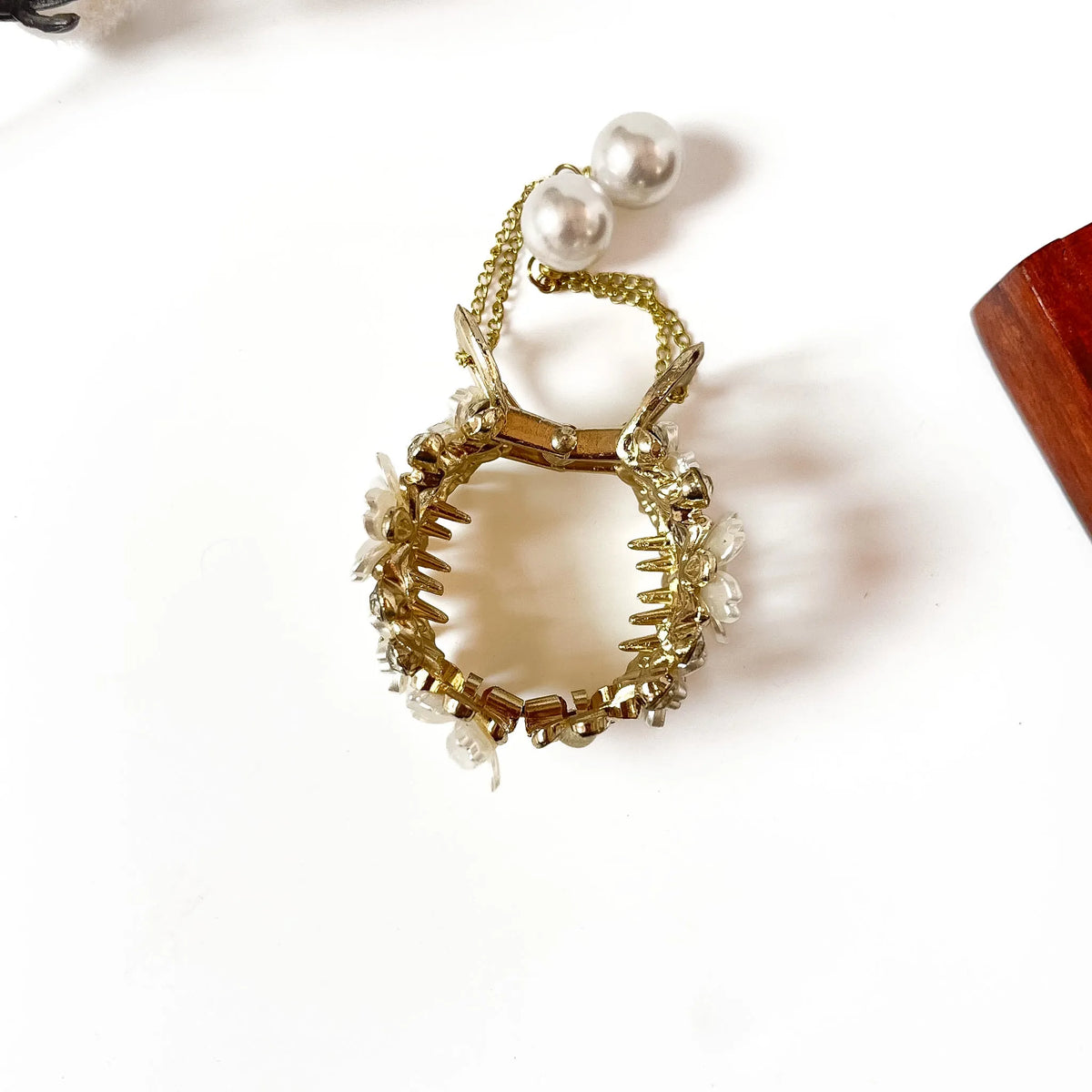 Close-up of white floral center medallions with pearl beads and rhinestone accents
