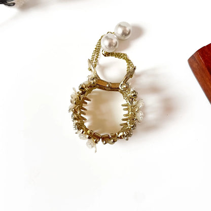 Close-up of white floral center medallions with pearl beads and rhinestone accents