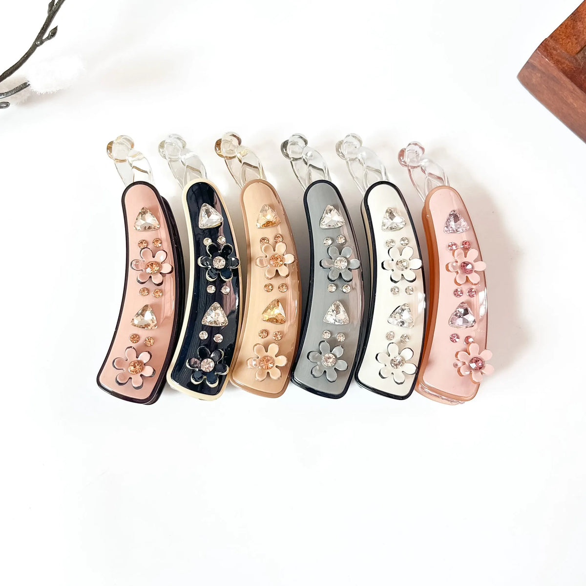 Set of 6 large jeweled blossom banana clips in peach tan, black onyx, honey golden, slate grey, ivory white, and blush pink. Each features crystal rhinestones, pearl-centered flowers, and triangular gem accents. Perfect for thick hair, curly hair, and fine hair. Large luxury fancy banana hair clips with handcrafted sparkle.