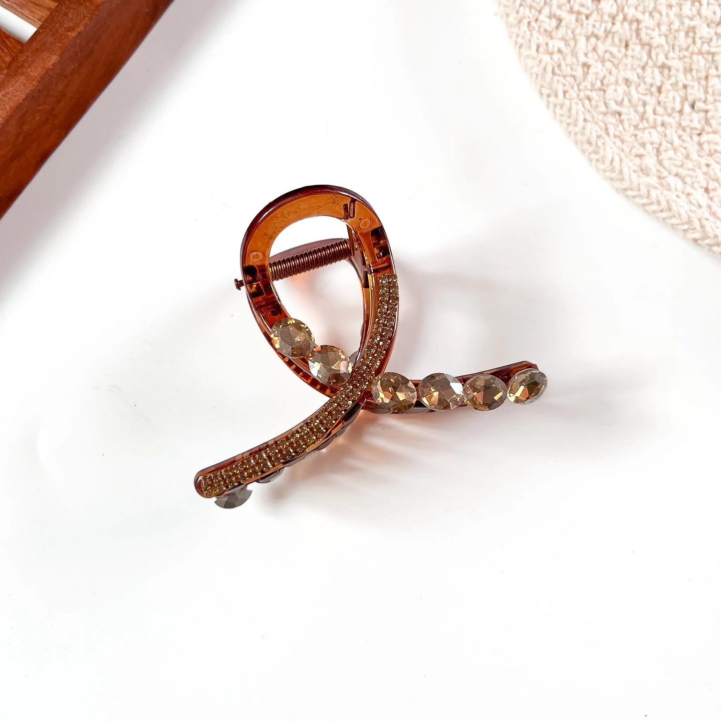 Amber gold-toned large stone claw clip with rose-tinted crystal accents and polished finish.