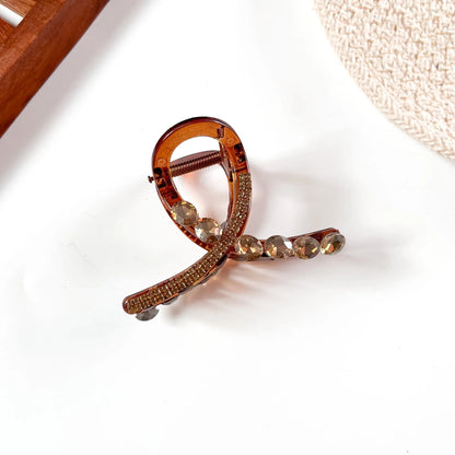 Amber gold-toned large stone claw clip with rose-tinted crystal accents and polished finish.