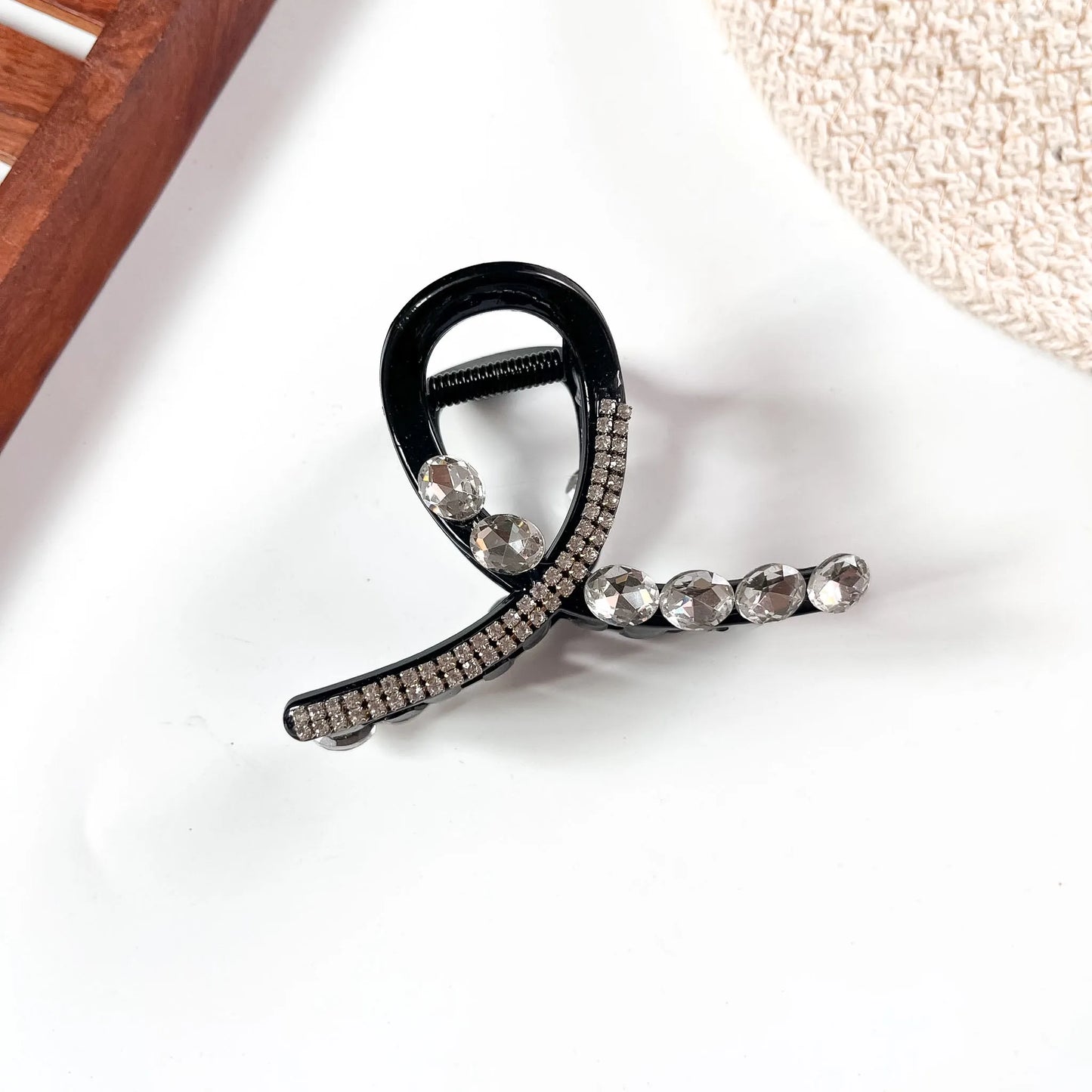 Black large claw clip with faceted black rhinestone embellishments across the bow and loop body