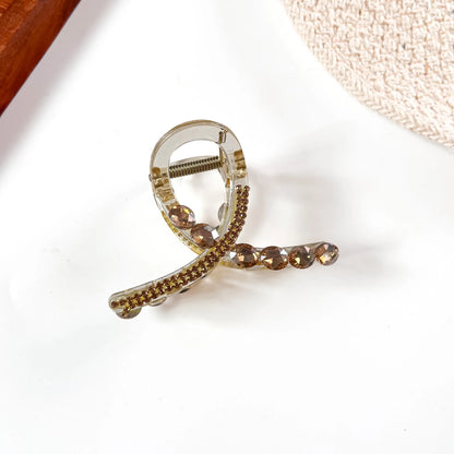 Rose gold-toned large stone claw clip with rose-tinted crystal accents and polished finish.