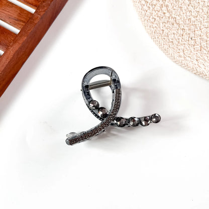 Grey black large stone claw clip featuring champagne crystal accents and dark metallic claw grip.