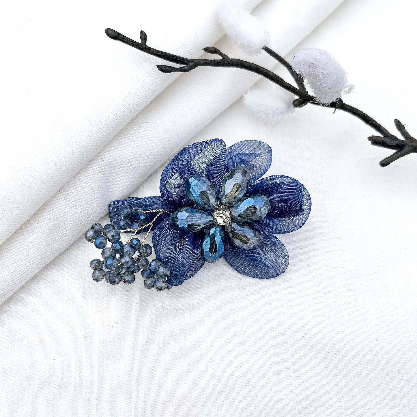 Blue ornate alligator clip with layered mesh petals, crystal faceted flower and berry clusters