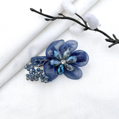 Blue ornate alligator clip with layered mesh petals, crystal faceted flower and berry clusters