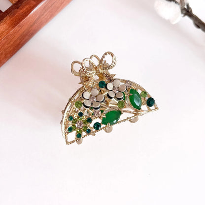Emerald green ornate pearl bow clip with filigree metal and faceted gemstones, medium-thick clip