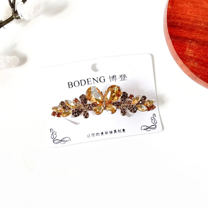 Champagne gold crystal butterfly hair clip with rhinestone trail, a jeweled barrette for weddings