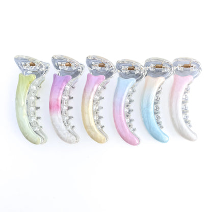 Set of six colorful banana clips on a white background