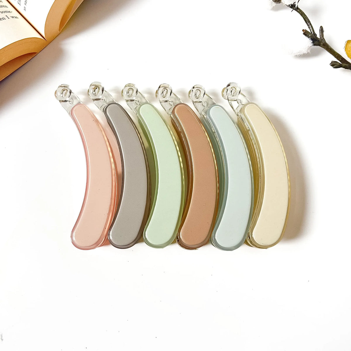Six pastel pop banana clips in Blush, Slate, Sage Green, Vanilla, Cognac, and Sky with smooth resin finish for medium hair