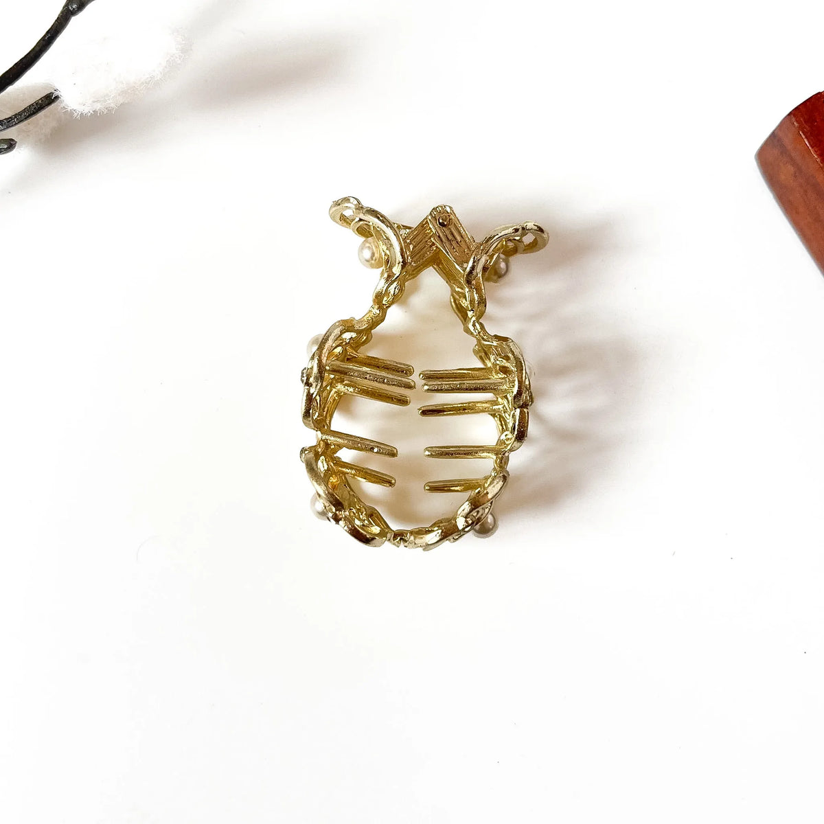 Close-up of gold rose metalwork with pearl center stones and rhinestone accents