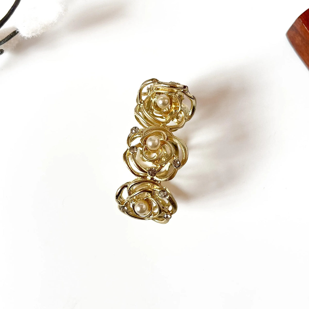 Pearl rose pony cuff with three floral rose medallions and pearl centers in gold