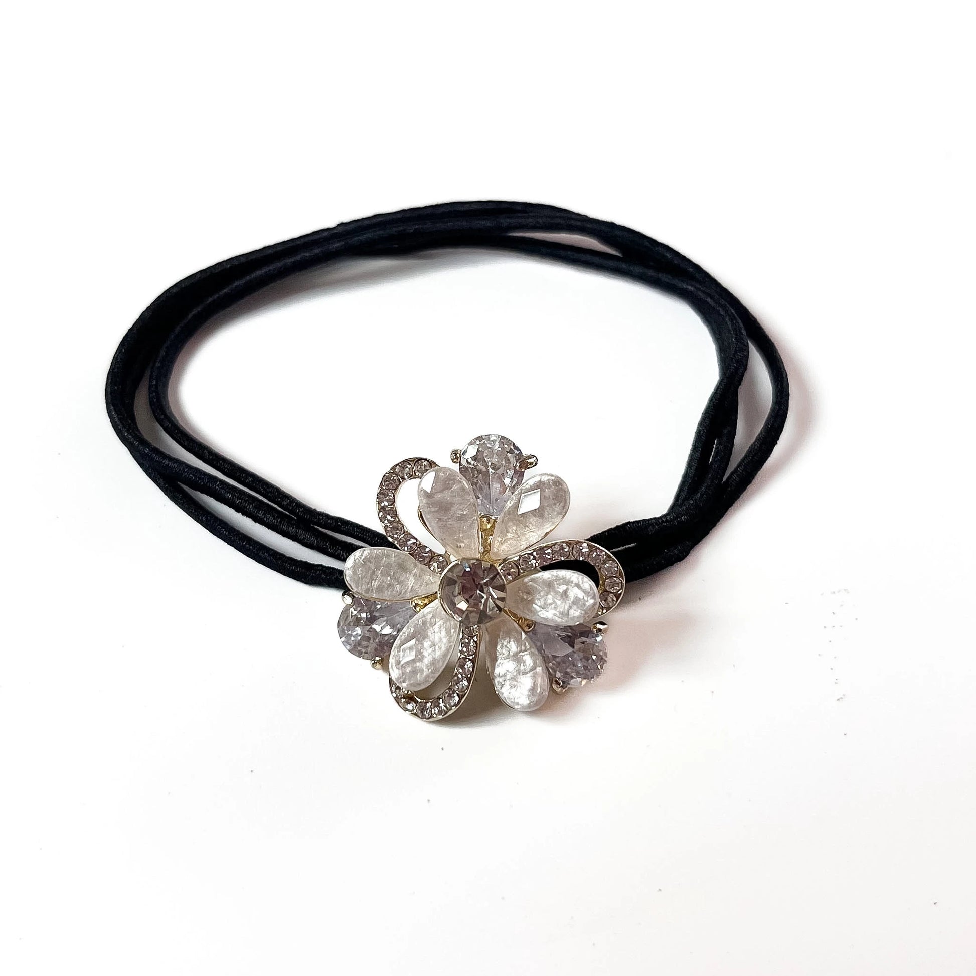 Clear white petal bloom flower hair tie with rhinestone swirl frame on black elastic band