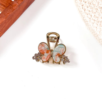 Coral and light blue resin butterfly metal claw clip with oversized wing detail and gold-tone metal frame with crystal bead sides.