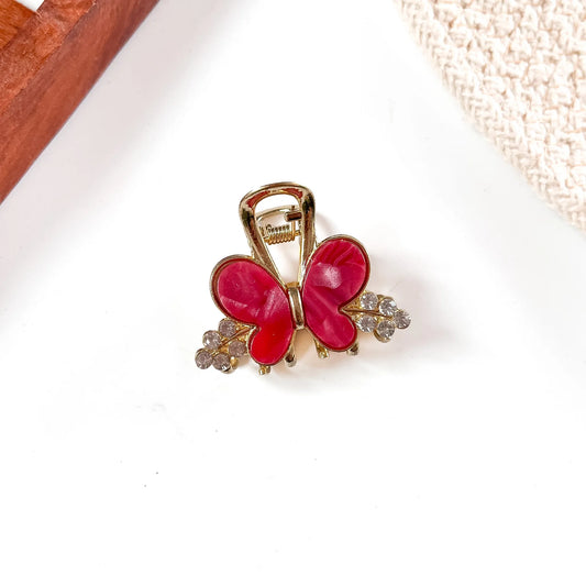 Vibrant hot pink resin butterfly metal claw clip with glossy wing finish and gold alloy spring claw mechanism with faceted beads.