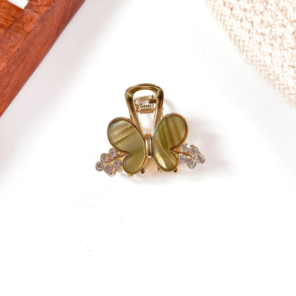 Khaki olive green resin butterfly metal claw clip featuring muted earthy butterfly wings and crystal bead embellishments.
