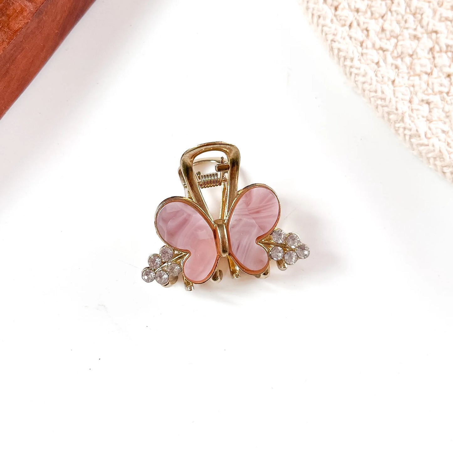 Soft mauve pink resin butterfly metal claw clip featuring large painted butterfly wings and sparkling crystal bead accents.