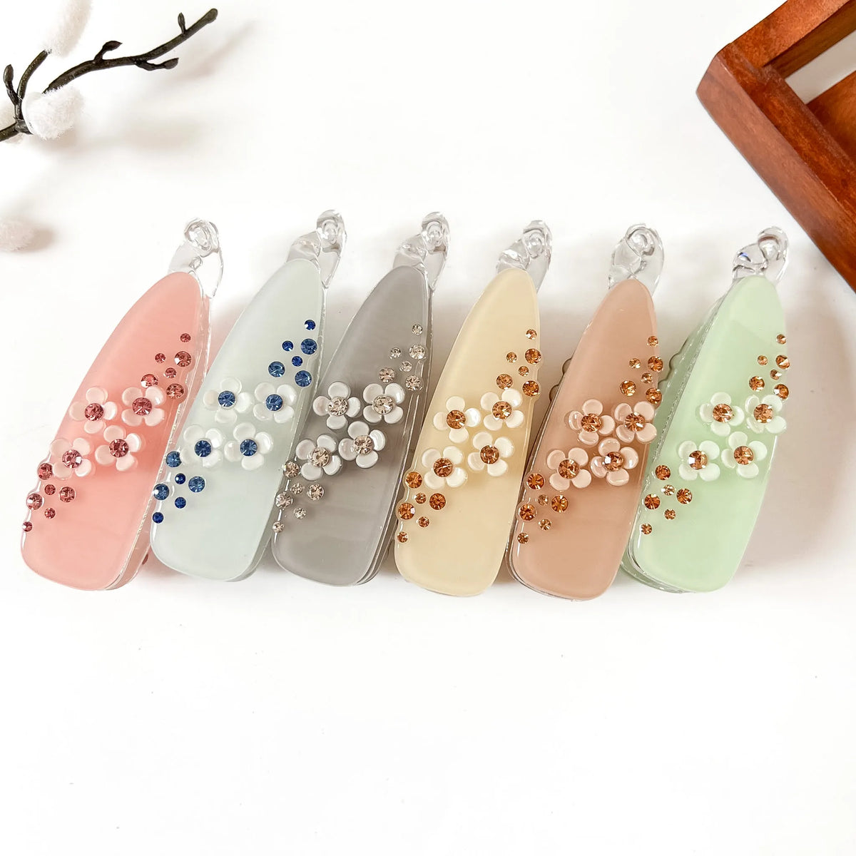 Set of 6 large teardrop banana clips in blush pink, sage green, slate blue, vanilla cream, cognac peach, and mint green. Each with scattered gem rhinestones and white flower center accent. Perfect for thick hair, curly hair, and fine hair. Large fancy banana hair clips.