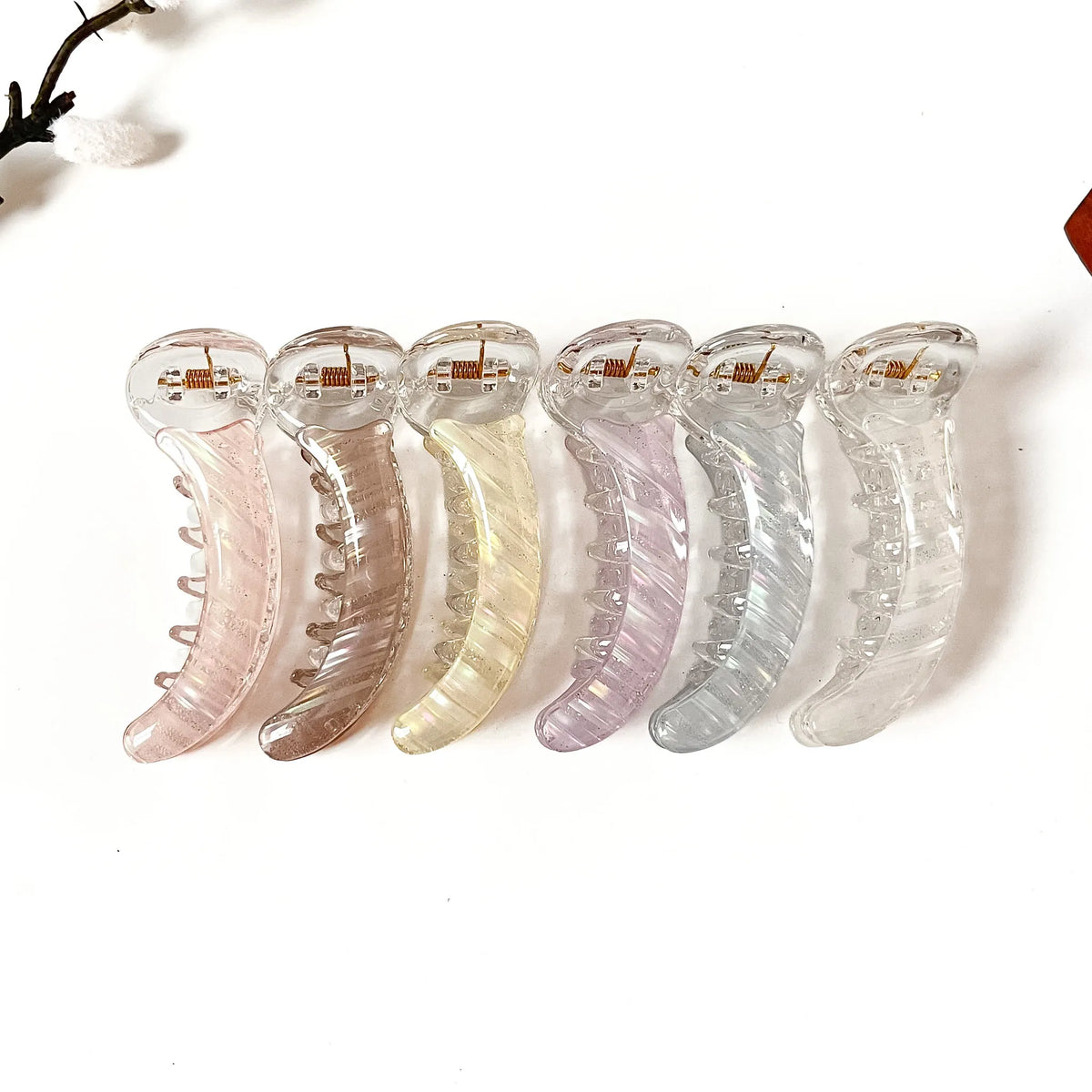 Shimmer Swirl 8 cm clear banana hair clips in blush pink, mocha brown, butter yellow, lilac purple, frost blue and crystal clear with glitter swirl